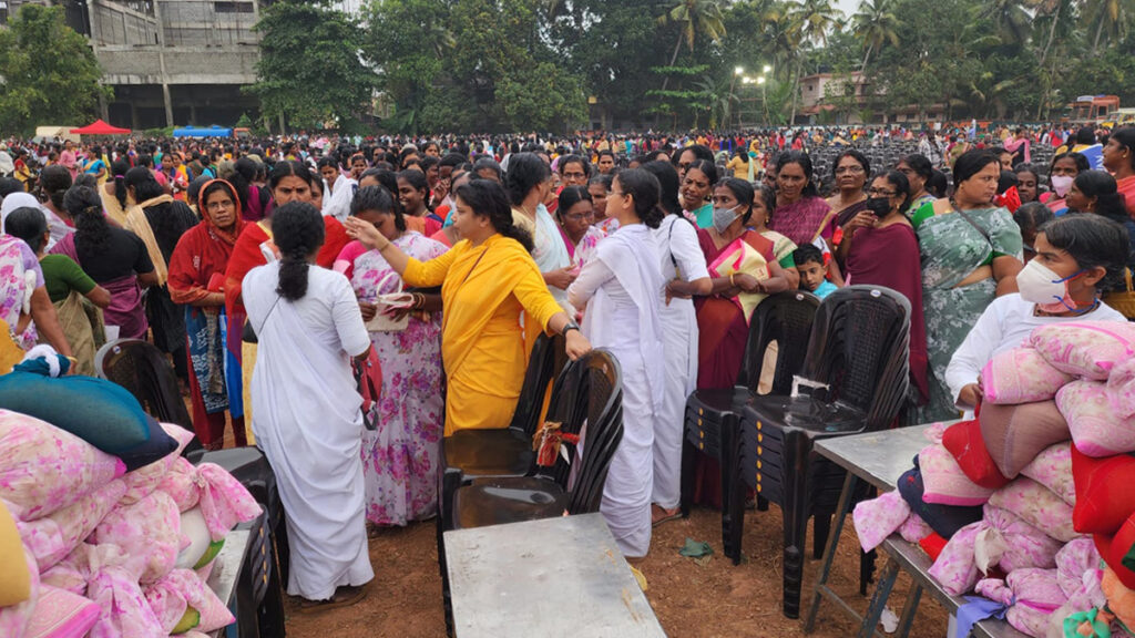 Large crowds of women wait to receive aid