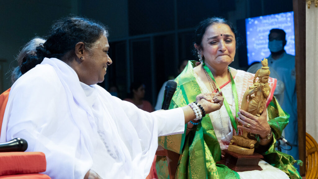 Amma holds Dr. Sandhya's hand