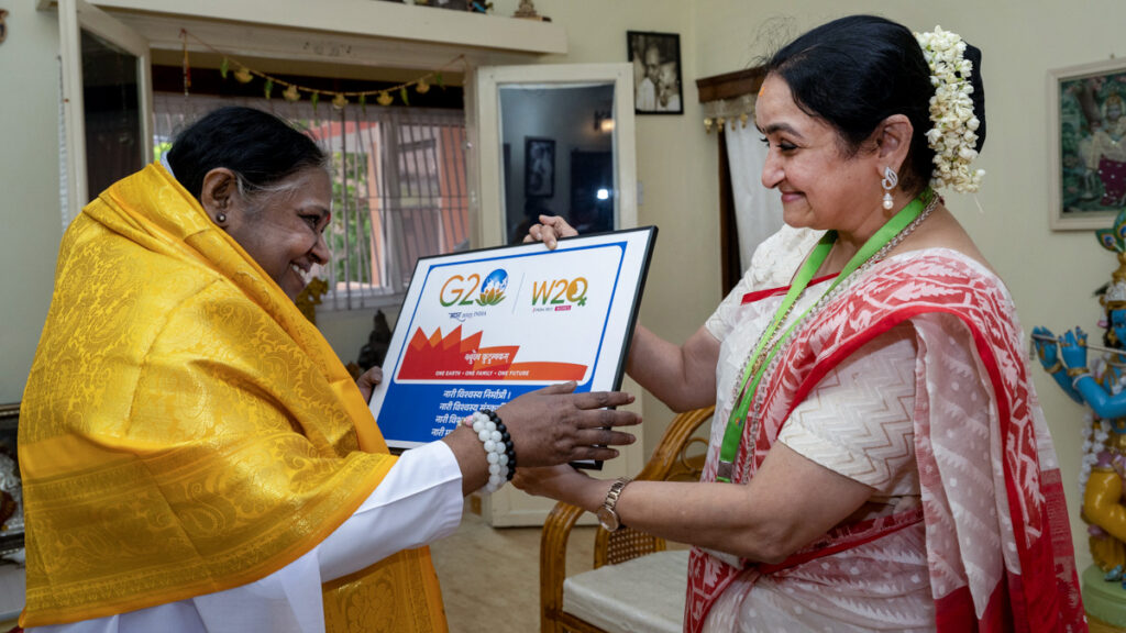 Amma and Dr. Sandhya hold a placcard about C20