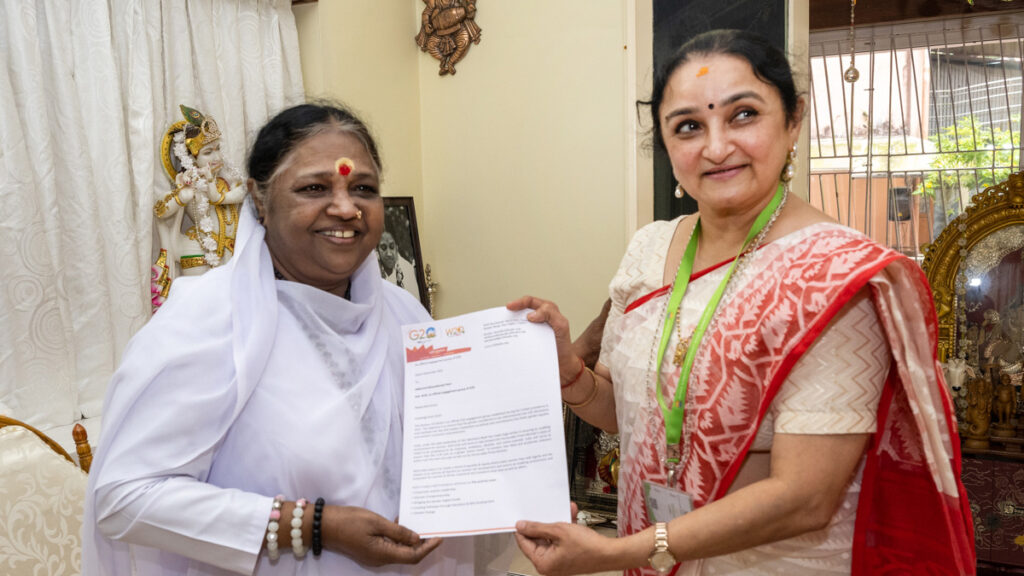 Amma and Dr. Sandhya hold C20 paperwork