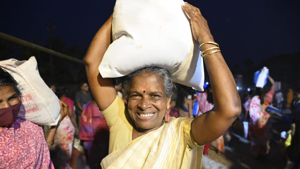 Elderly woman walks with her bag on her head