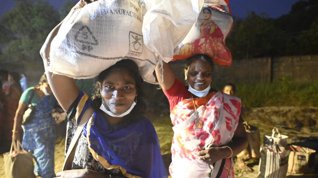 Two women carry goods on their head