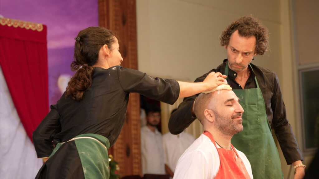 actors in one of the performances: a woman placing her hand on the head of a sitting man with another man standing by