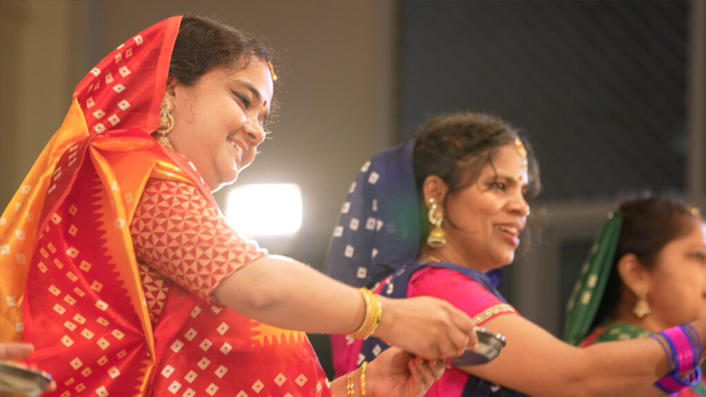 three women in traditional indian outfits dancing 