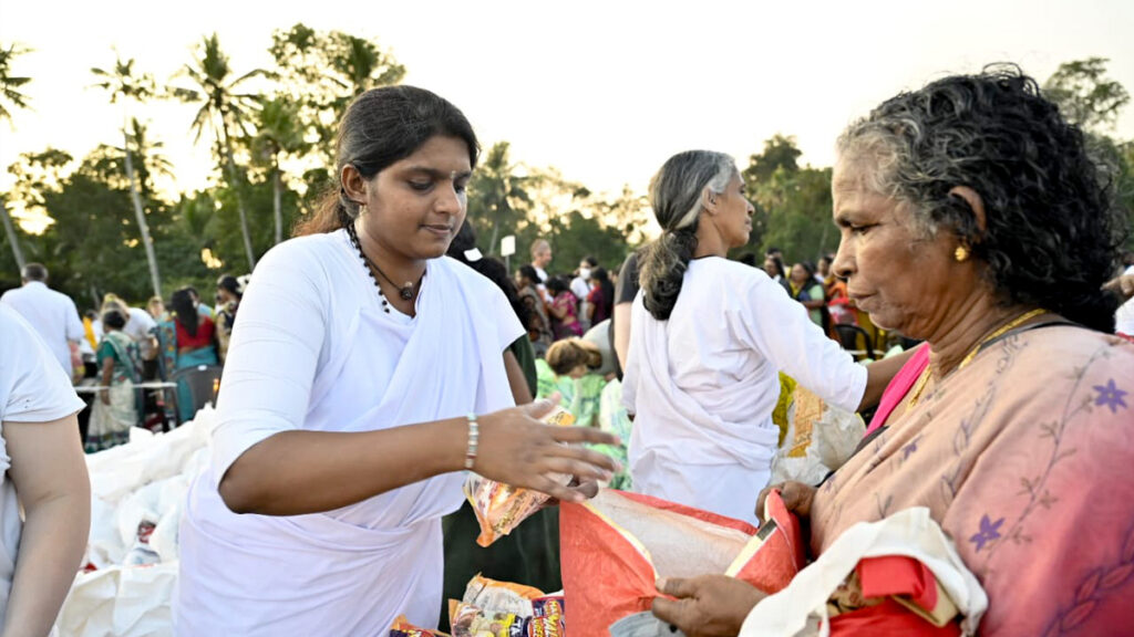 Amritapuri Ashram female monastic hands out food items