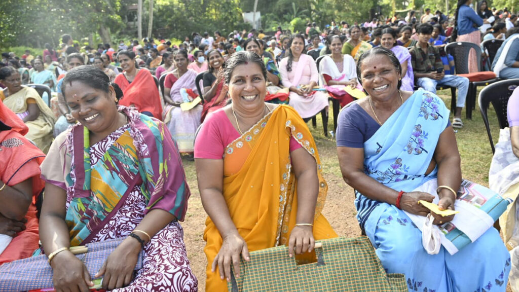 Women sit and smile during program