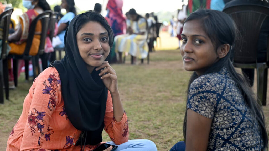 Two girls turn to the camera and smile