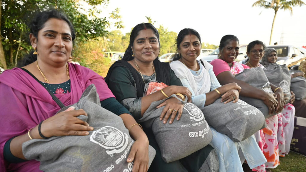 A row of women with matching bags sit and smile