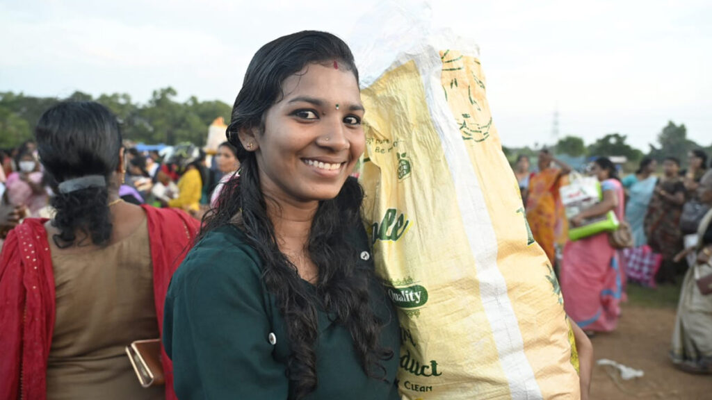 Young woman holds her bag of groceries and smiles