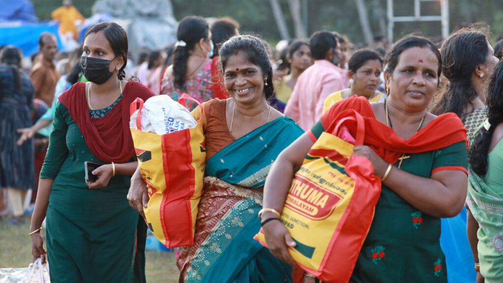 Women walk and smile with their bags of food and clothes