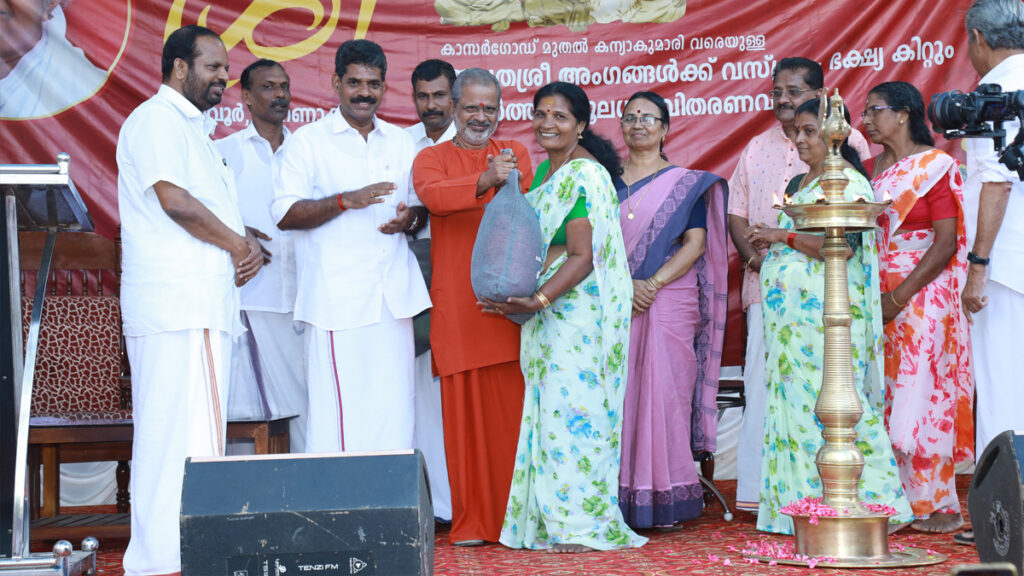 On stage, a woman receives a bag of aid