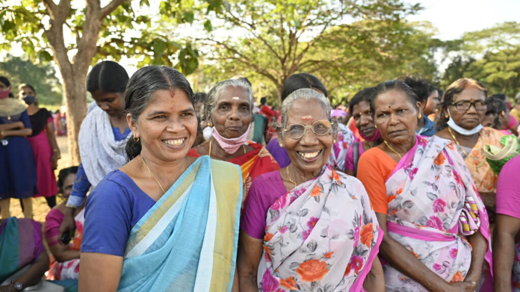 Village women stand and smile