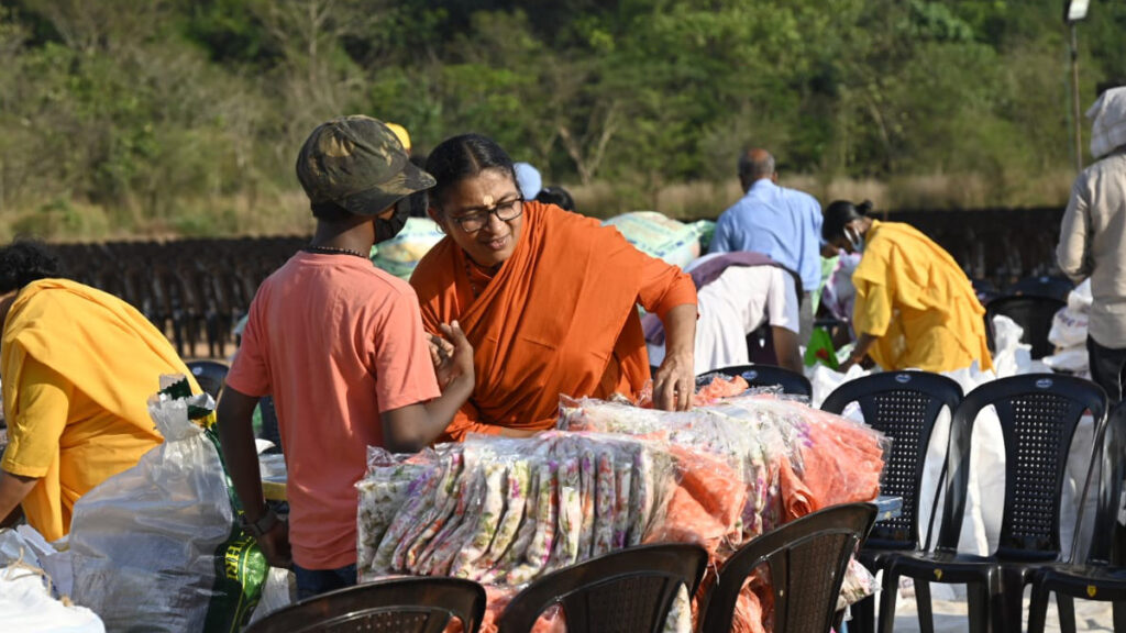 Monastic from Amritapuri Ashram unwraps saris for distribution