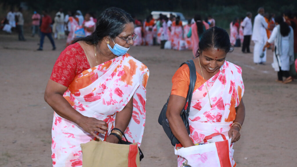 Women walk away, happily looking at their goods