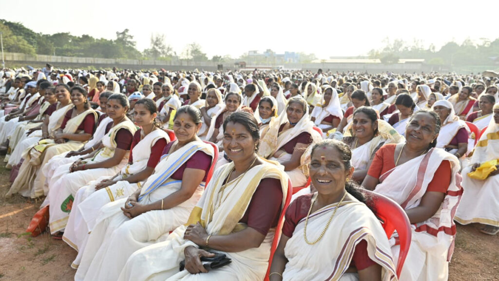 Hundreds of Indian women smiling as a part of the Amrita SREE meeting.