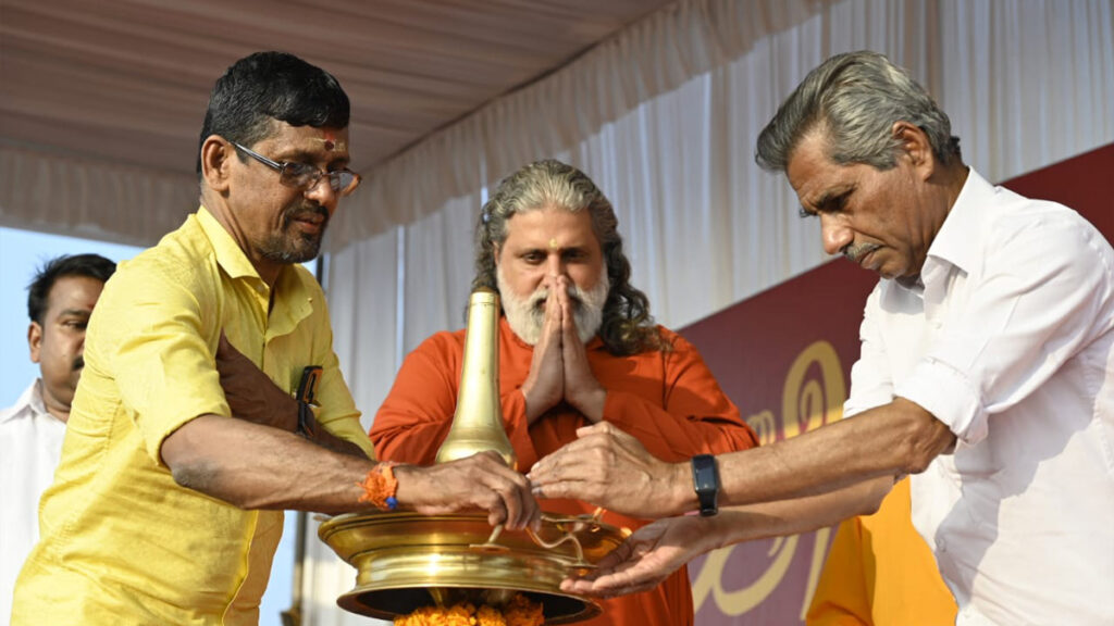 Swami Amritakripananda Puri and R. Ranganathan, Coordinator Amrita SREE, light a large lamp for the traditional form of worship called arati. 