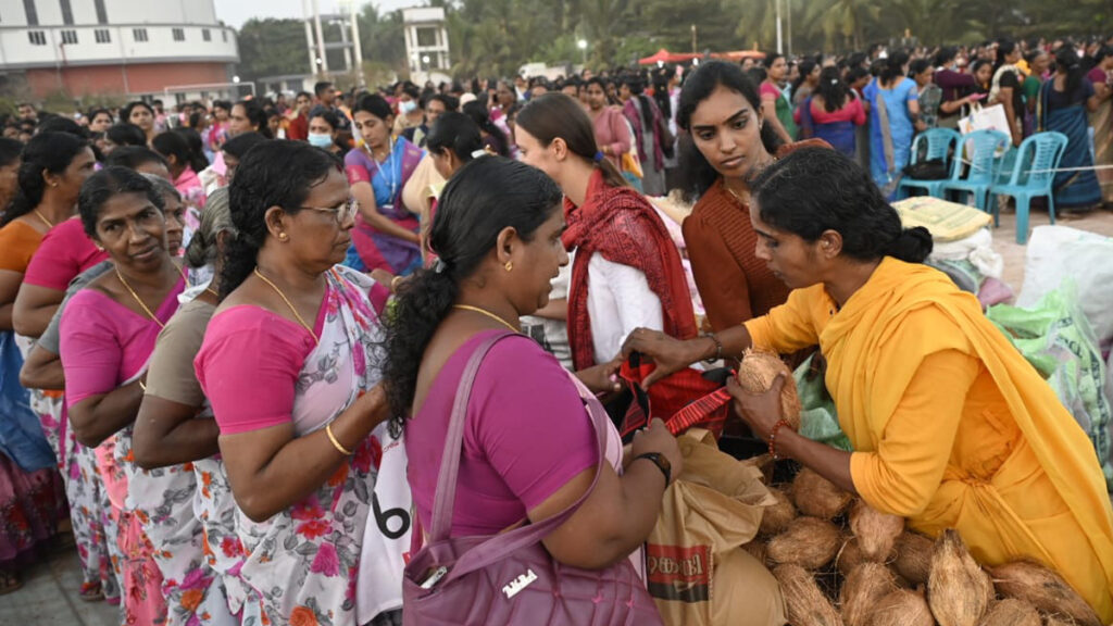 Women wait to receive coconuts from bramacharini