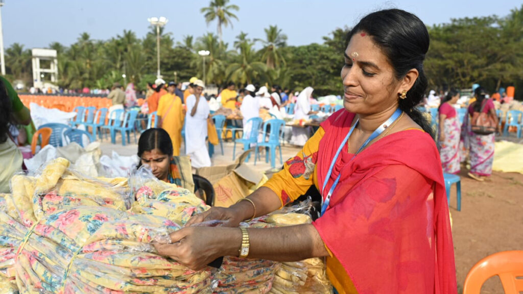 A woman counts saris that will be gifted to recipients