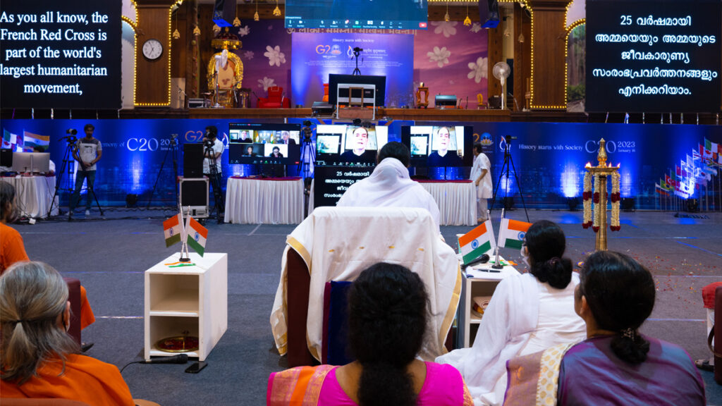 Amma listens to other speakers via video