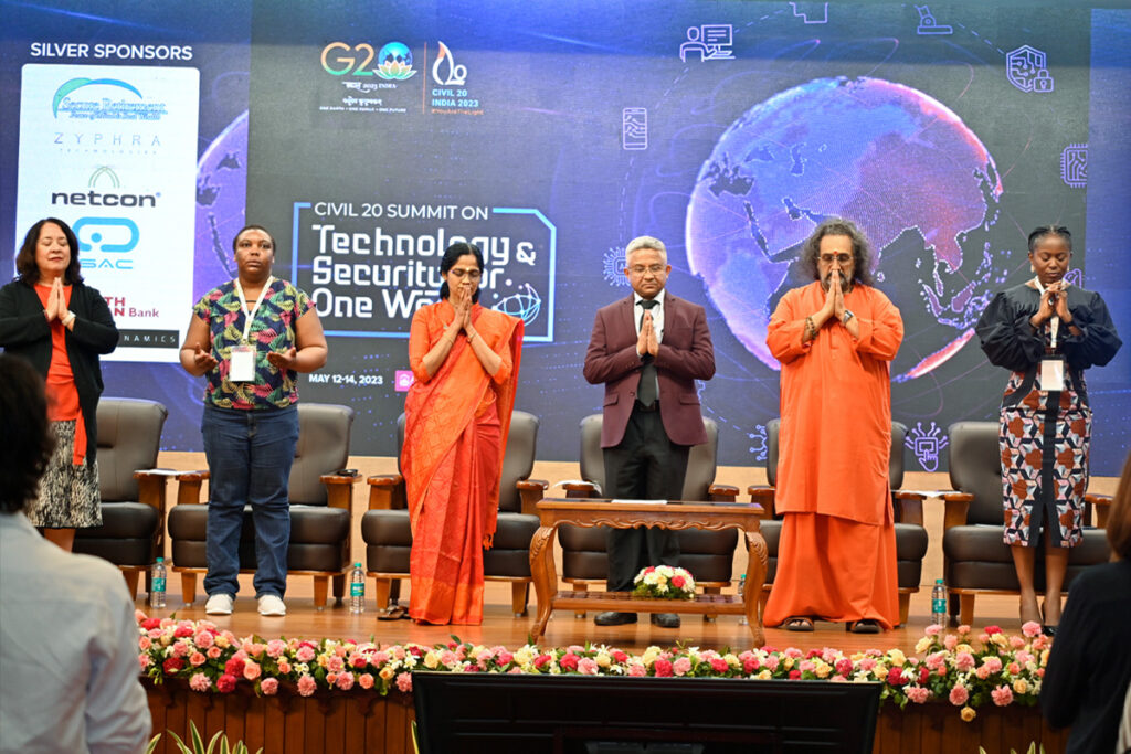 In pranam, Swami Amritaswarupananda Puri, stands with all the speakers on stage.