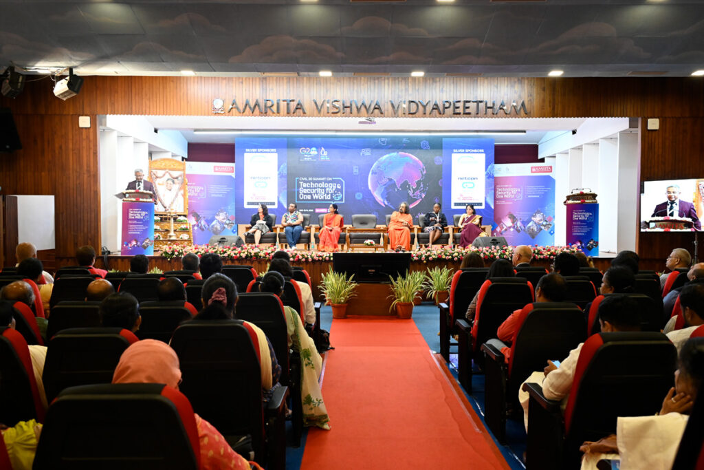 A red carpet divides the audience in two, as the stage is lit up with a blue backdrop of the earth behind all the speakers on stage.