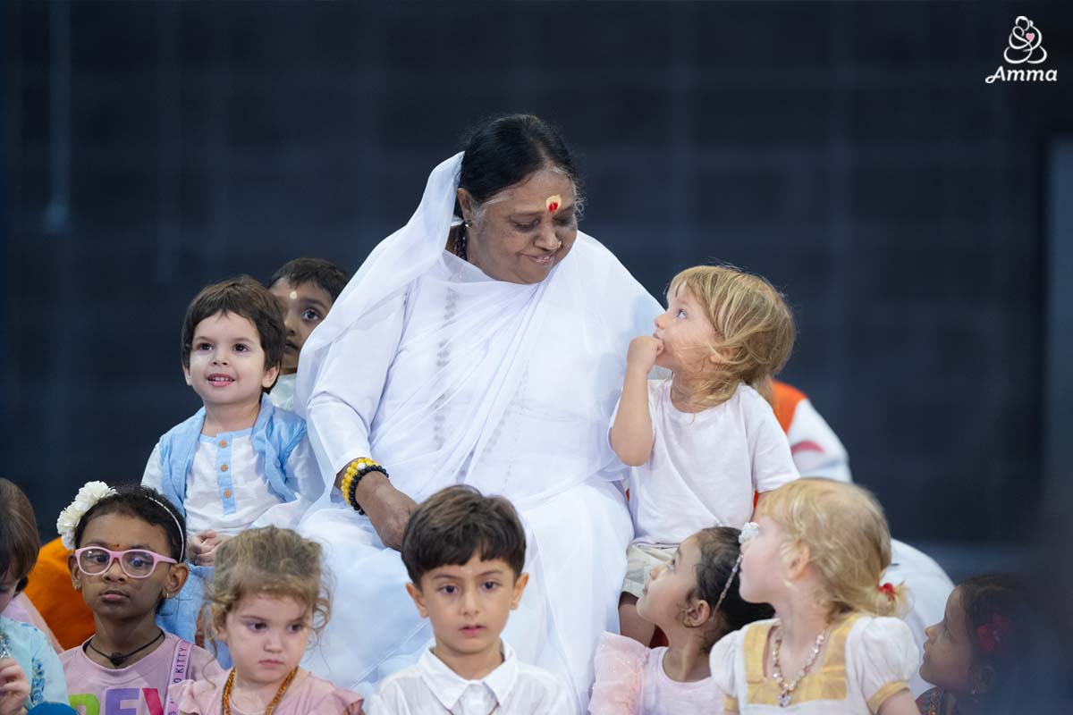 Amma looks at a child who smiles back