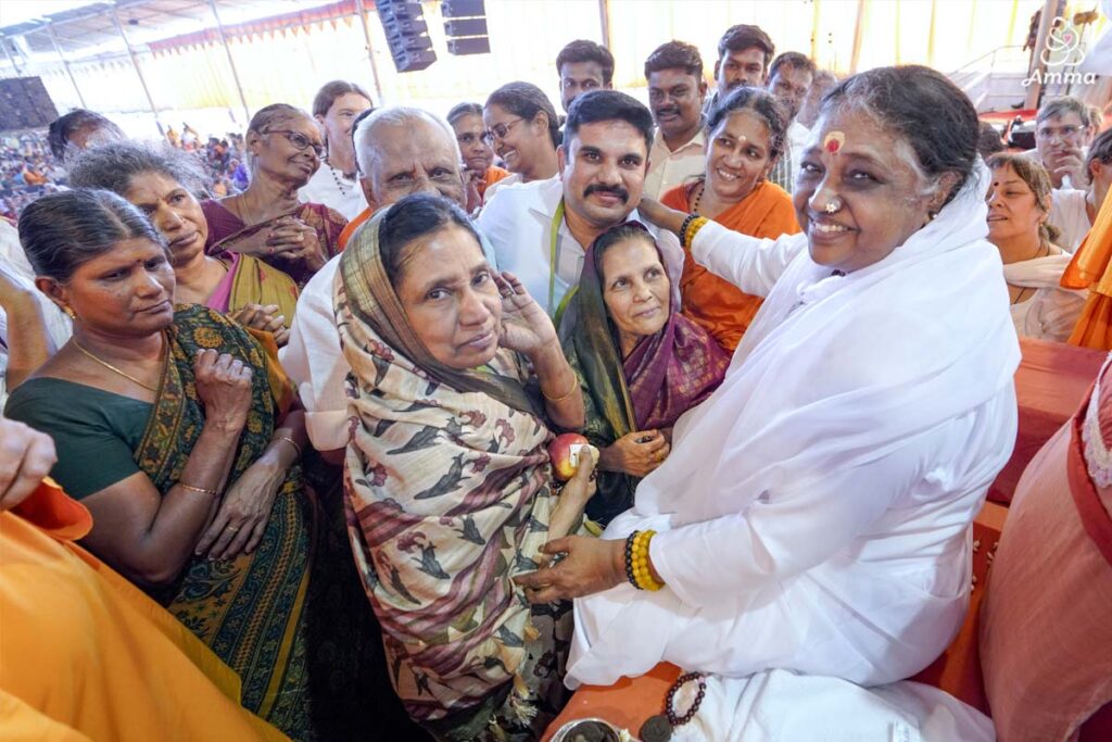 Amma gives darshan to a family