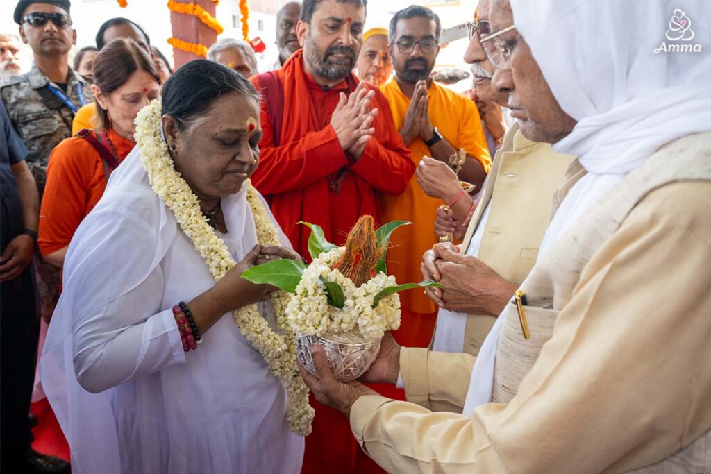 Amma is welcomed with a traditional decorated coconut