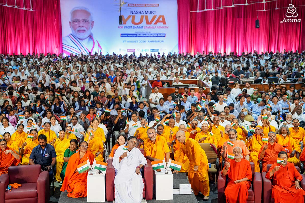Amma with a crowd in the Ashram Hall