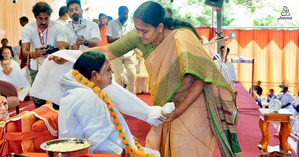 A woman garlands Amma