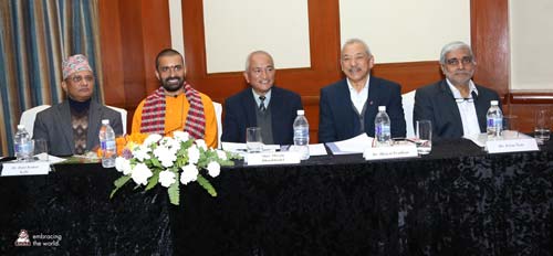 Dr. Prem sits with officials at a long table