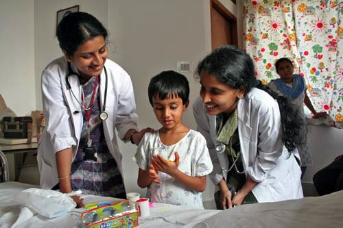 Two doctors speak to child and smile