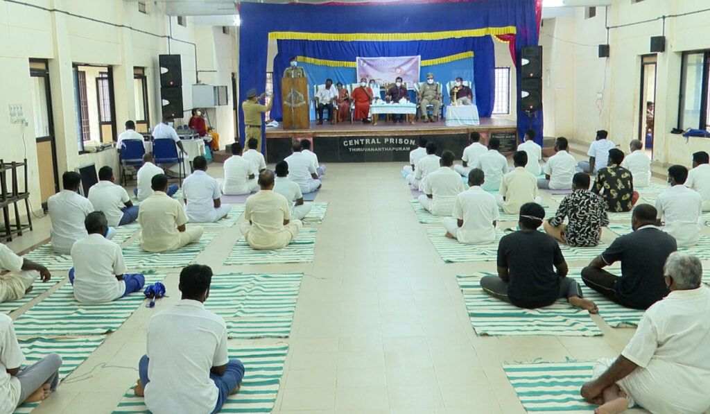 Prison inmates are attentive and focused on Swami Gurupadashritananda give yoga instruction.