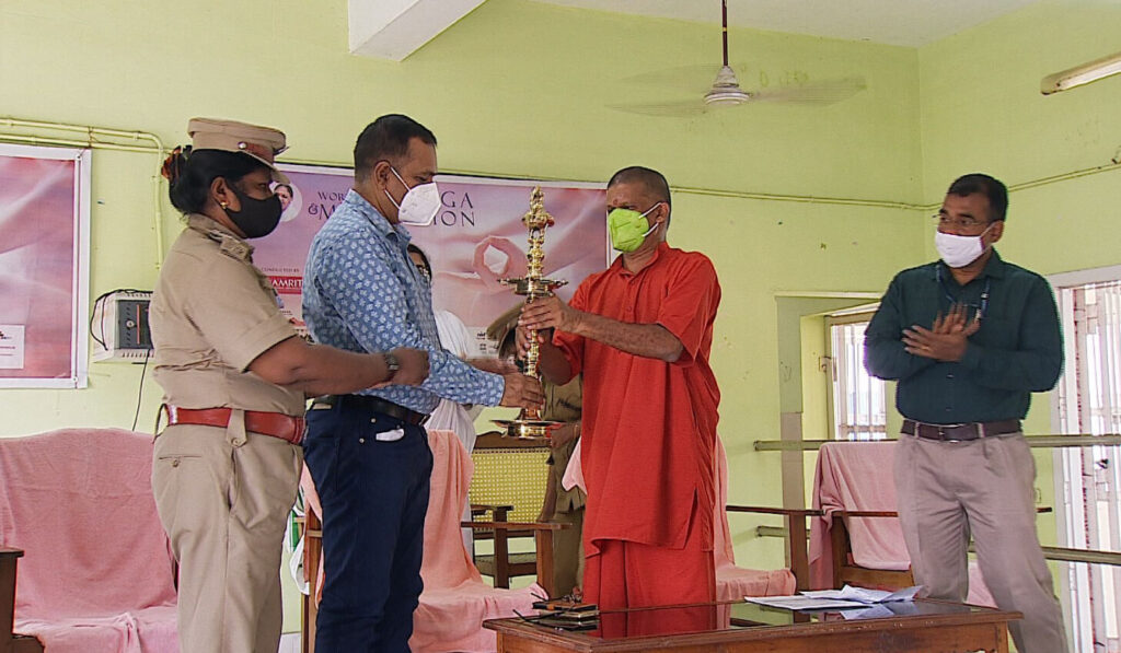 Swami Gurupadasthritananda hands a shiney brass Arati lamp to the Prison Officials.