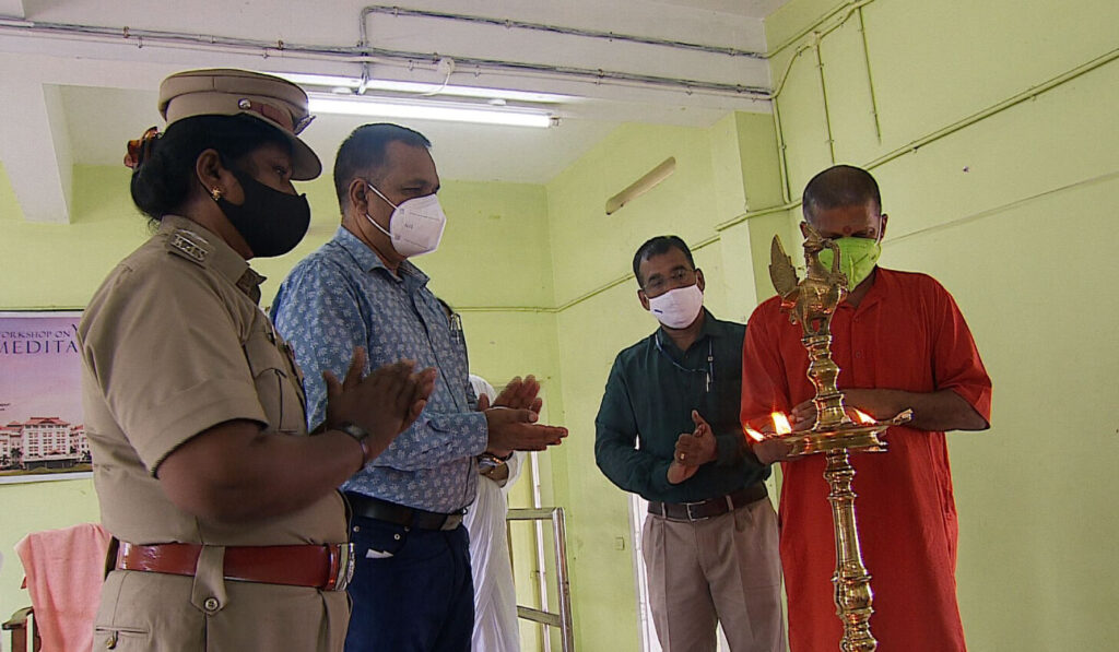 Swami Gurupadasthritananda bows in reverence at the Arati lamp with prison officials.