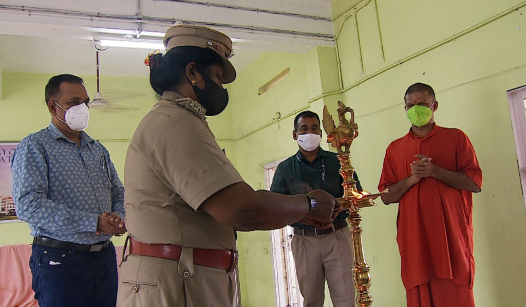  A female prison officer lights the Arati lamp.