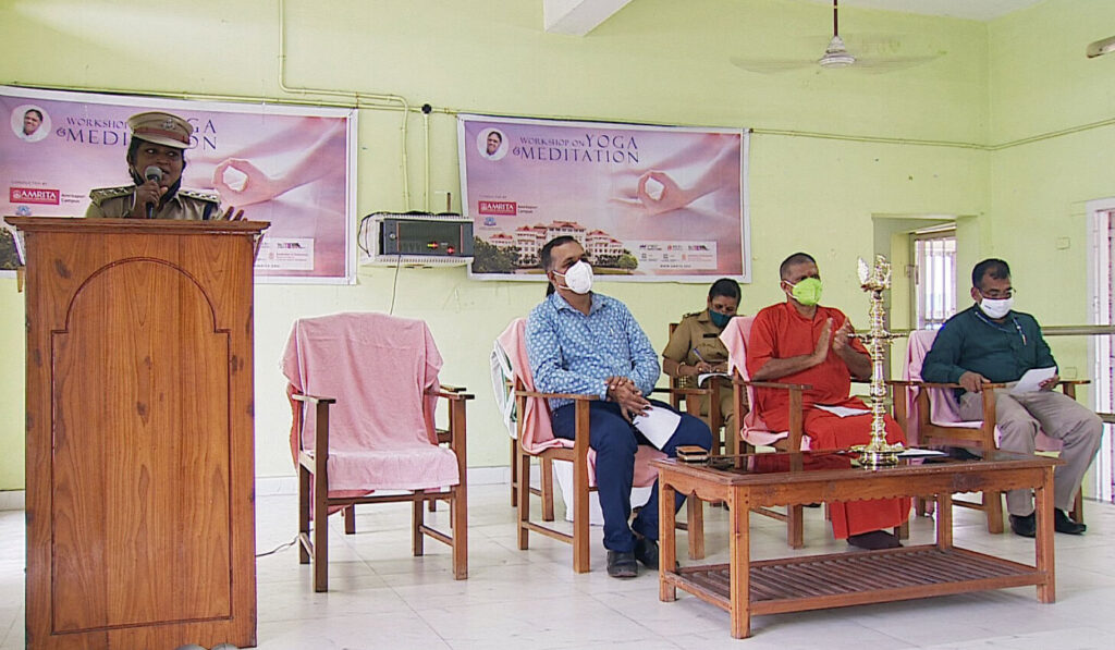 A female prison officer at the podium on the stage, addresses the value of this program to the inmates.