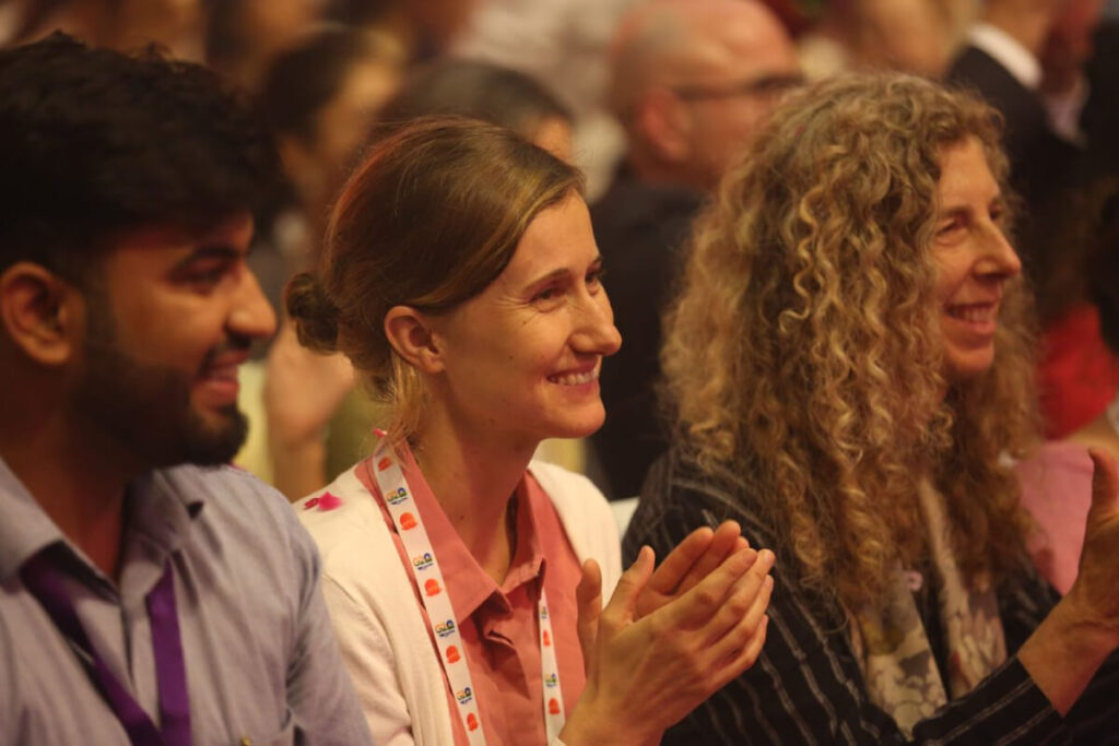 3 participants smile while enjoying cultural programs