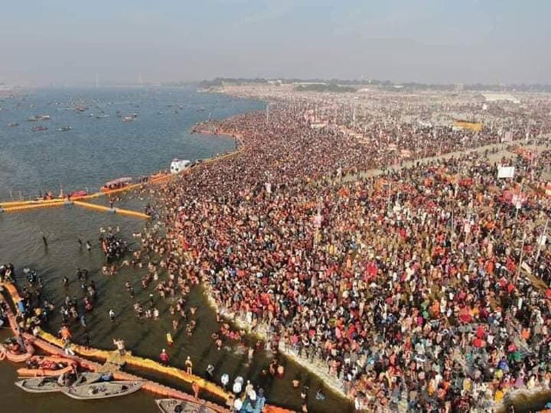 Aerial view of the Kumbh Mela showing thousands of tents with the Ganges River in the background