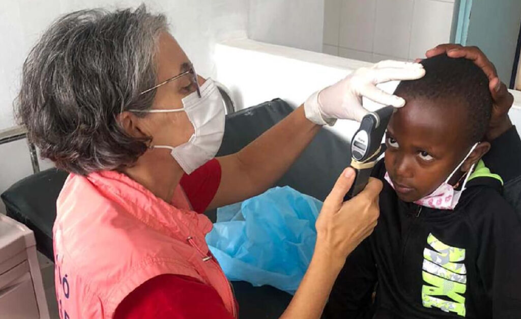 Dr. Solar uses an optomotrist instrument to examine Charity's right eye.