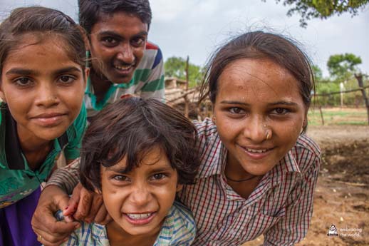 Village children laugh as they lean into the camera