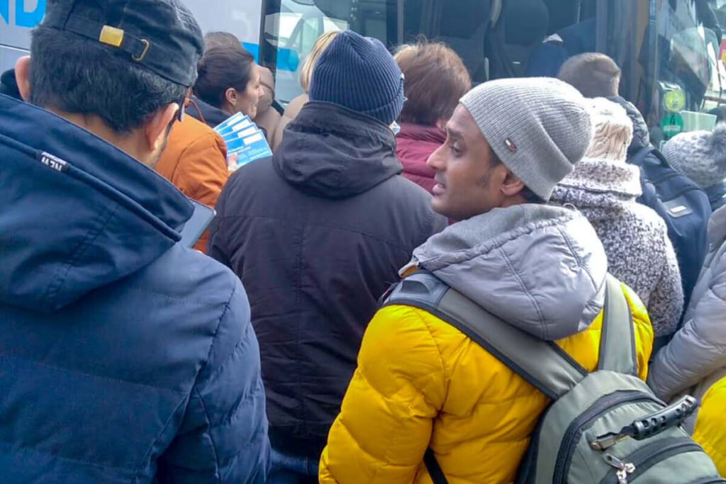 Students waiting in line to board a bus