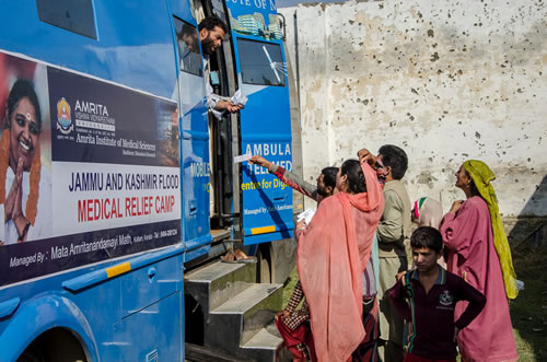 Villagers stand outside a telemedical vehicle