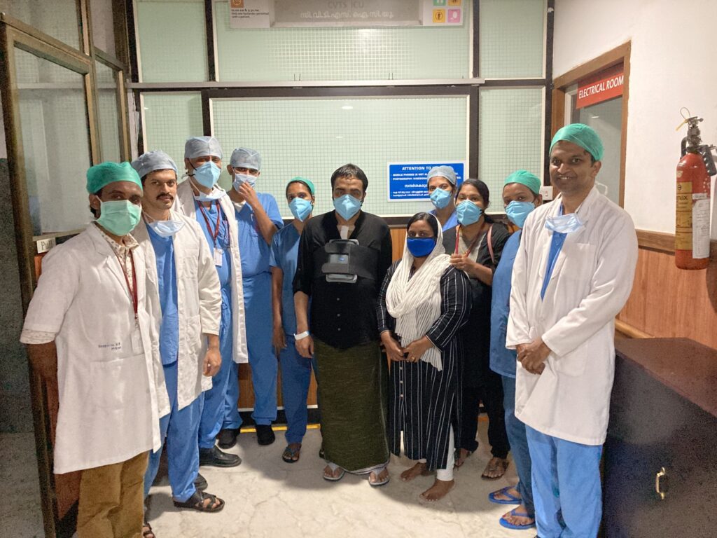 Doctors stand around recovered patient