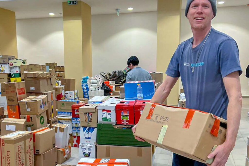 Matthias Schneiderhan holding boxes of supplies.