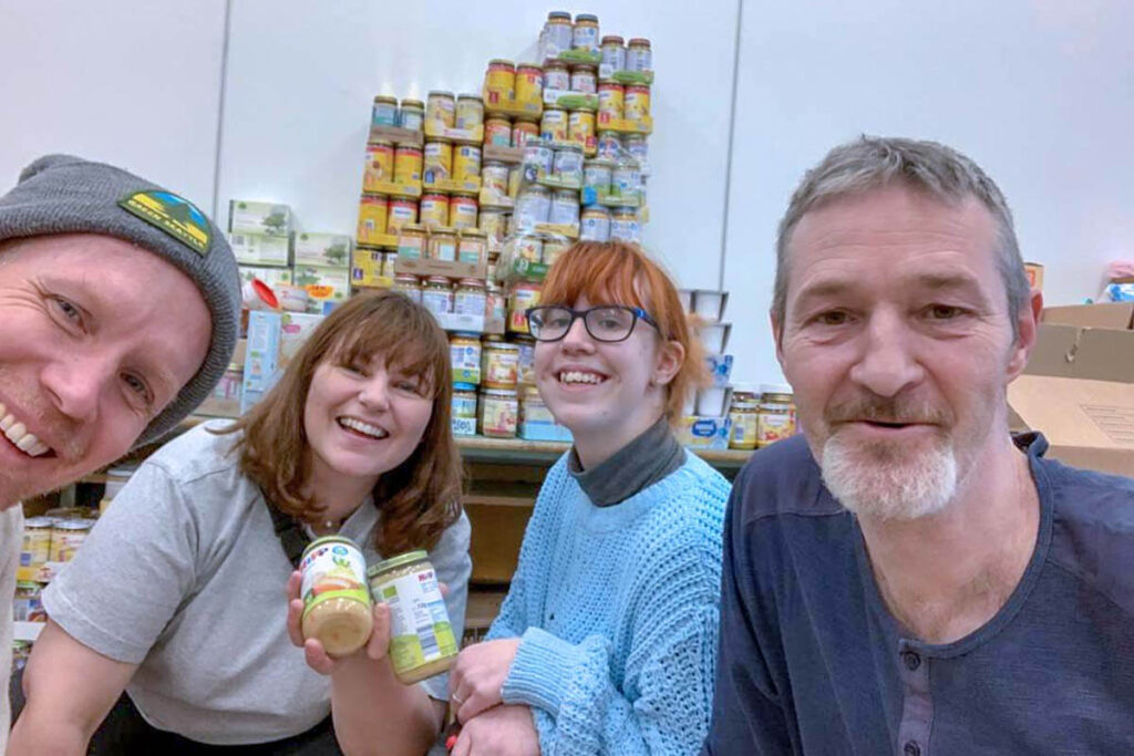 Volunteers smiling with food in their hands