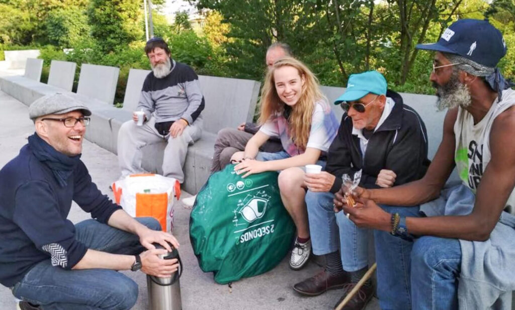 Volunteers sitting and speaking to an elderly man