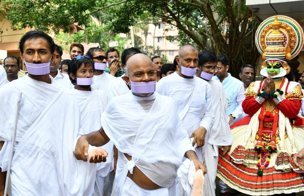 members of the yatra walking alongside with a man dressed in traditional kathakali dress