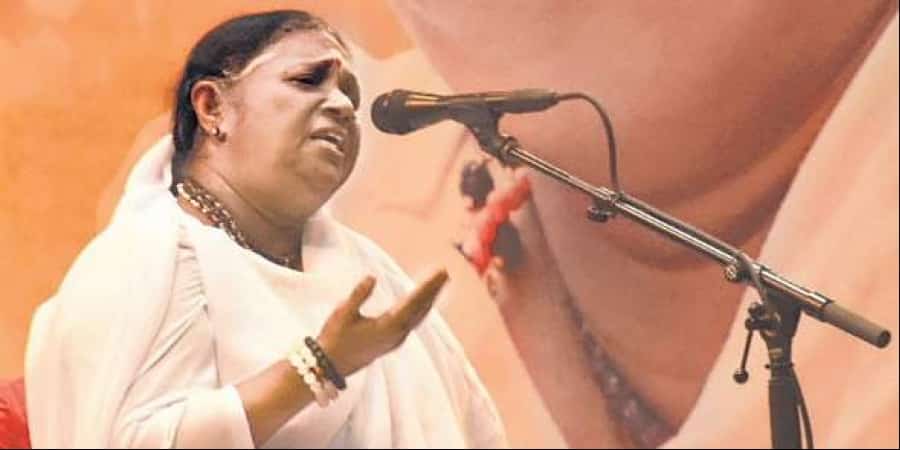 Amma speaking into a microphone.