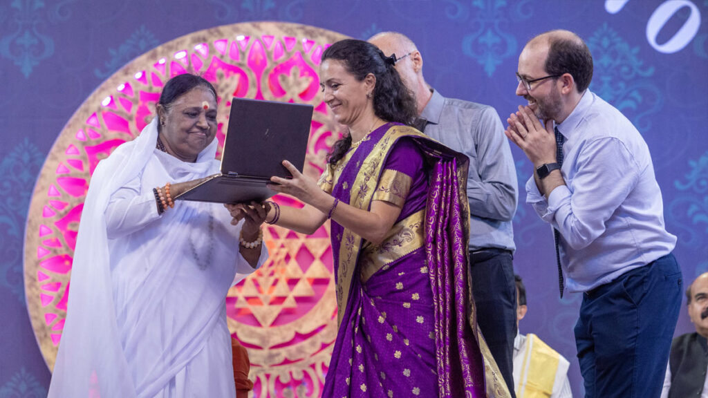Amma holds a computer, next to Ahalya, Bhuvanesh and Vinay